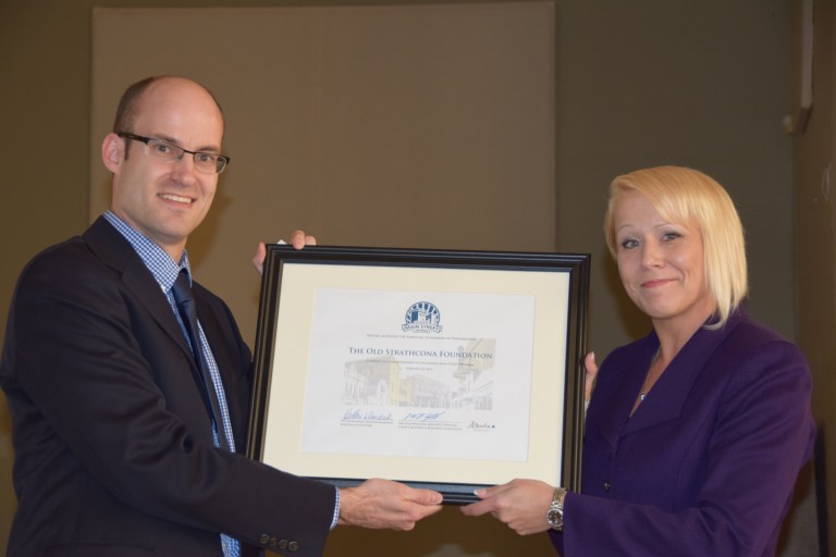 Alberta Historical Resources Foundation Executive Director Matthew Wangler presents the Alberta Main Street Program Membership to Angie McDow, President of the Old Strathcona Foundation. 