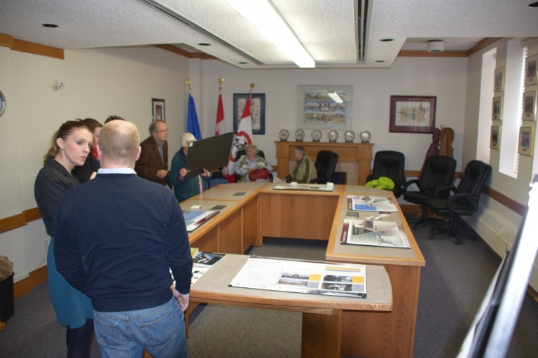 Image of people attending the open house in Raymond discussing the context paper.