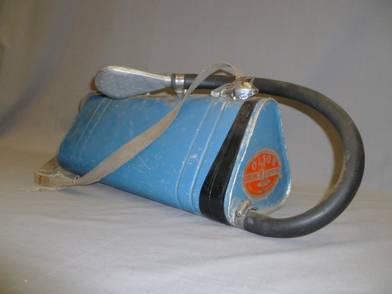 An ice pebbler, one of the Conjuring Lake Curling Club artifacts donated to the Alberta Sports Hall of Fame. It was invented by E.B. Olson, who founded Olson Curling Supplies, in Edmonton in 1933. Pebbling involves sprinkling warm water on the surface of the ice to give some grip for the rocks; if the ice was completely smooth it would not be possible to “curl” the stones.  (Photo by Judy Larmour, Courtesy of the Alberta Sports Hall of Fame.)