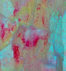 Photo-enhanced areas of red ochre smeared on Okotoks Erratic. Note hand prints at top.