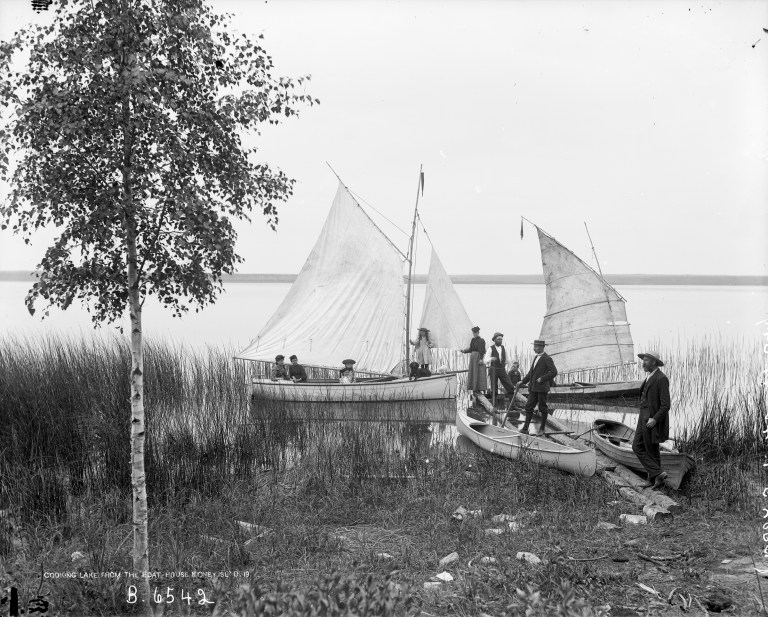 Koney Island Club member showing off their floatilla: The gaff-rigged sloop Mudhen, along with a row boat and two canoes, one with a small sail as was popular at the time. (Courtesy of the Provincial Archives of Alberta, B.6542.)